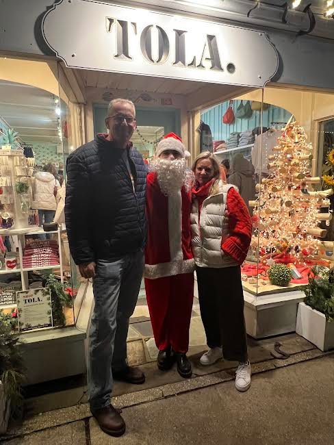 Alison Buck, owner of TOLA and co-president of the Bellport Chamber of Commerce, and her husband, Rob Wegener, pictured with Santa Claus at the successful event.